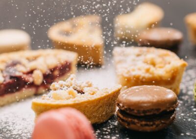 Close-up of delicious pastries and macarons dusted with powdered sugar.