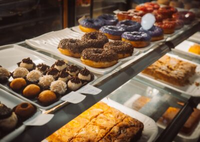 A variety of colorful donuts and pastries on display in a bakery case, enticing and delicious.